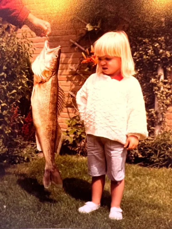 Foto vera toen ze nog klein was met een vis vies kijkend